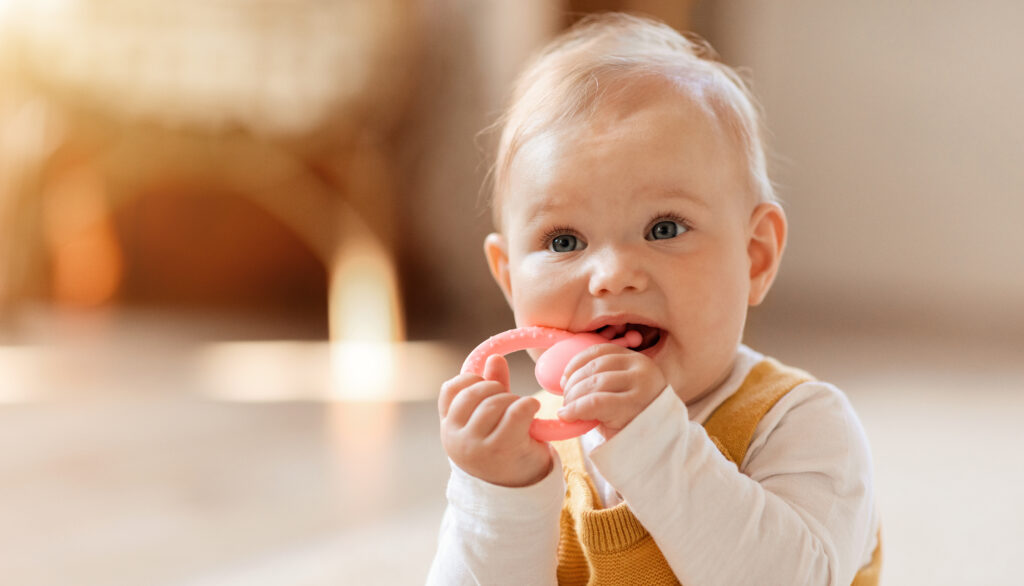 Baby chewing on a teething ring showing early signs of teeth grinding at Green Acres Family Dentistry pediatric dentist in Twin Falls, ID