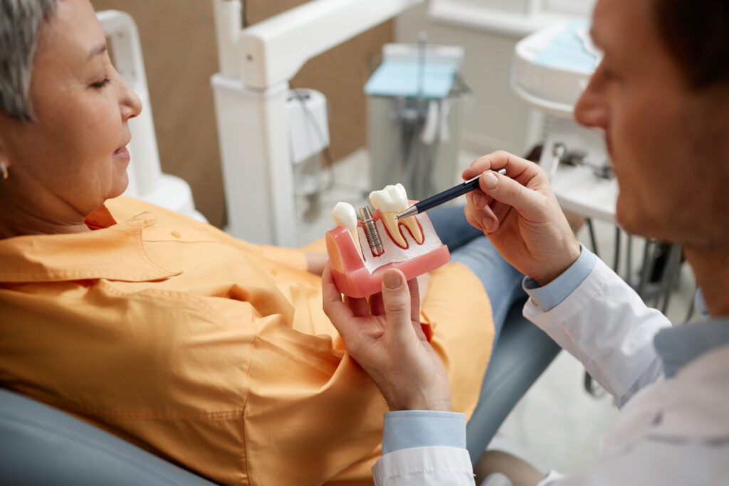 Dentist explaining dental implants model to a patient at Green Acres Family Dentistry in Twin Falls